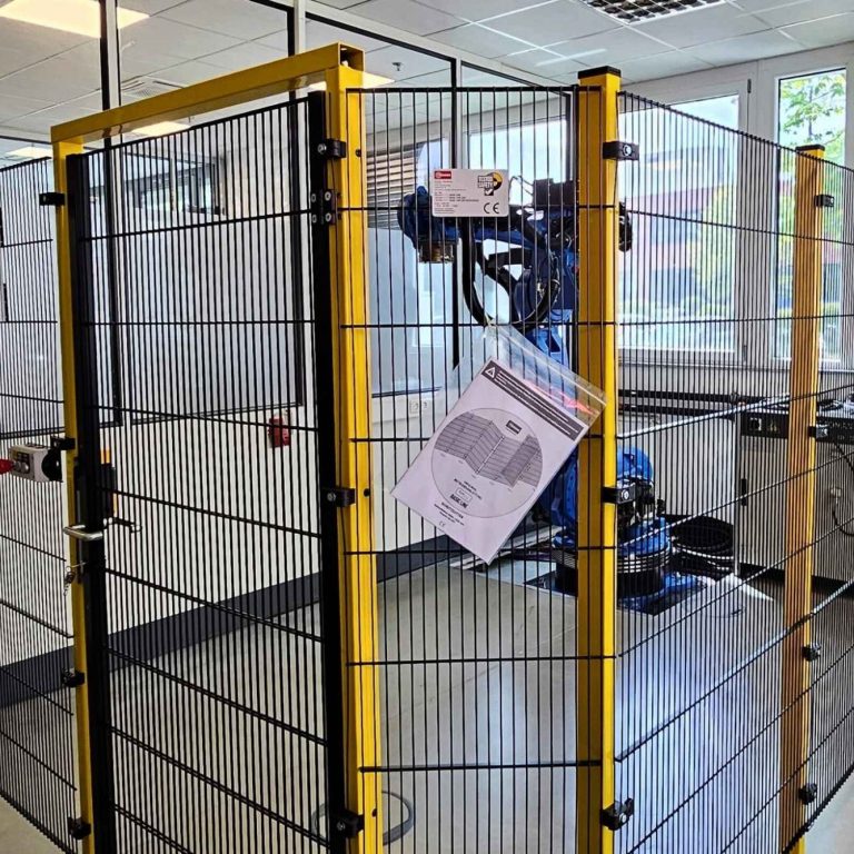Roboterzellen und Roboteranlagen Sicherheitszaun um einen Roboterarbeitsplatz in einer modernen Werkstatt.